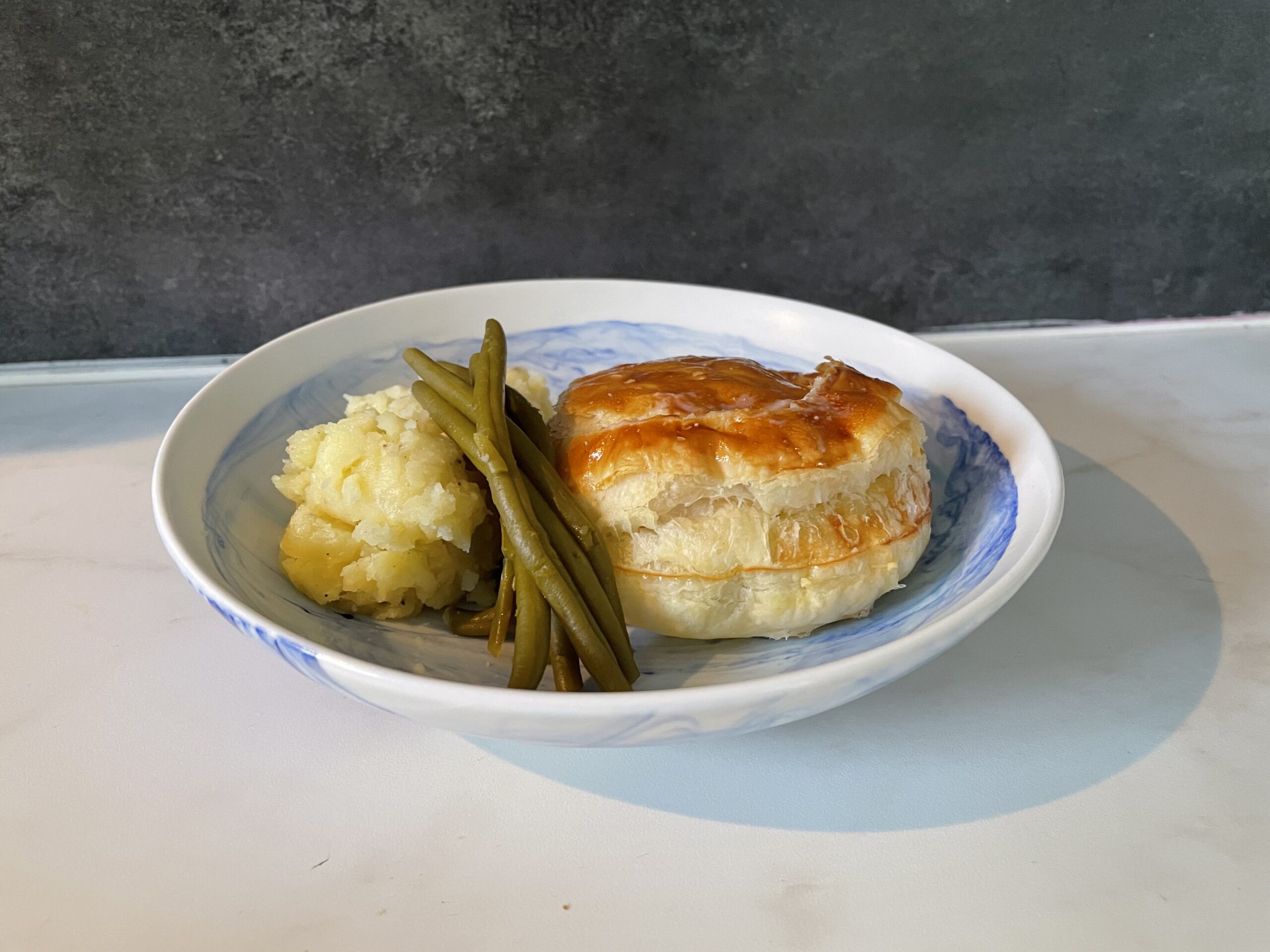 photograph of bouchee a la reine served with green beans and mashed potatoes